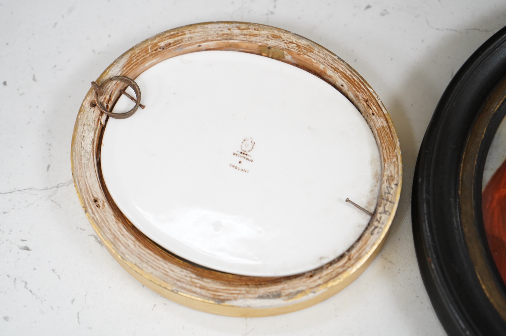 A collection of 19th century porcelain panels, pot lids and plaques to include a pair of hand painted floral lids, Russian lacquered box depicting a lady and a late 19th century Continental brass framed convex oval ename